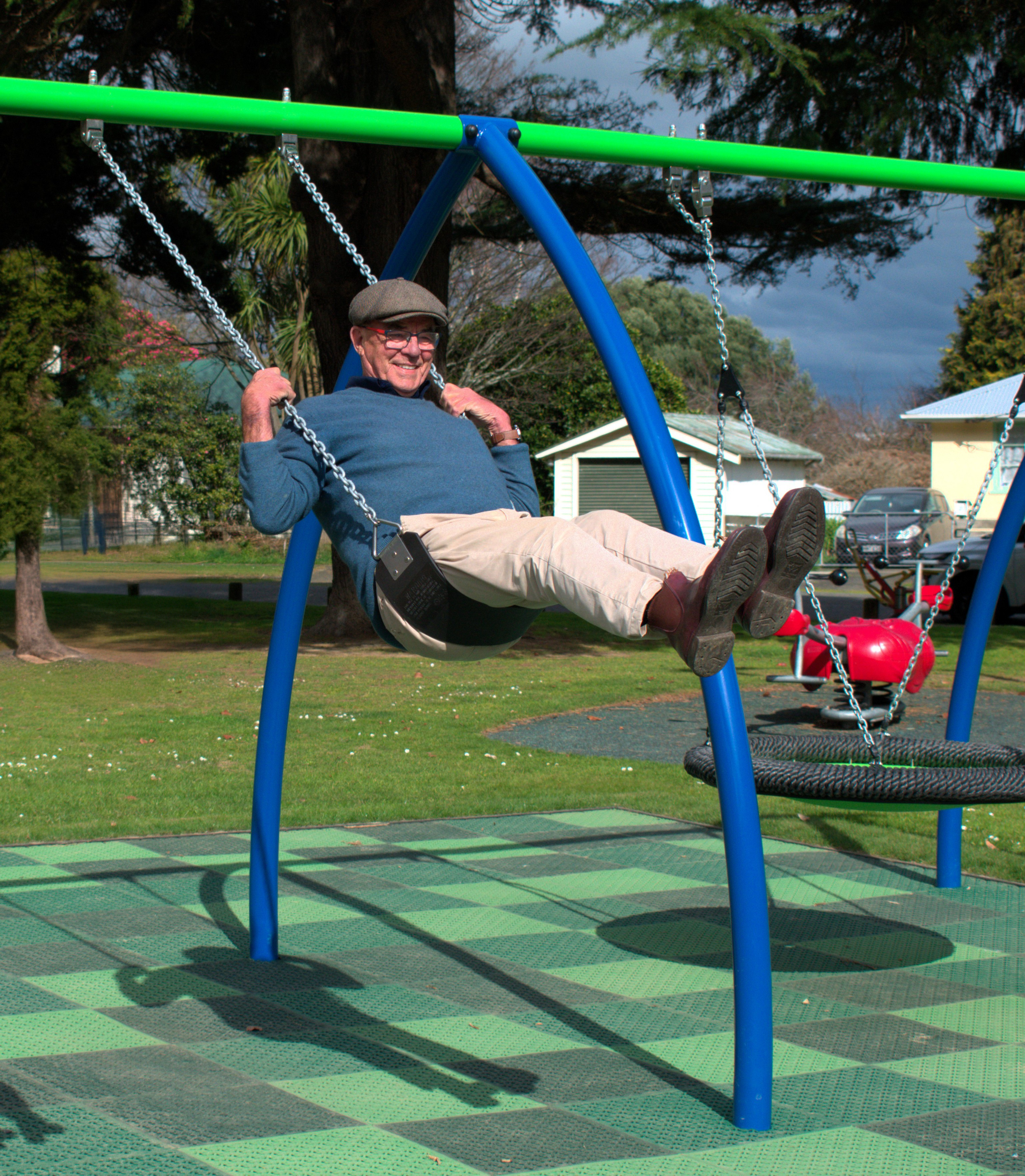 Photograph of Councillor Peter Johns on the swing of the Woodville playground after it was upgraded in 2025.